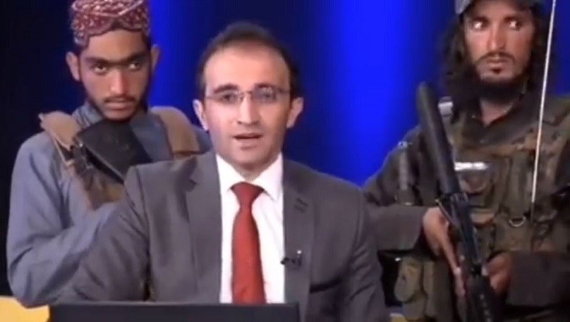 Conductor de TV afgana es vigilado por talibanes mientras emite mensaje “a favor de la paz”.